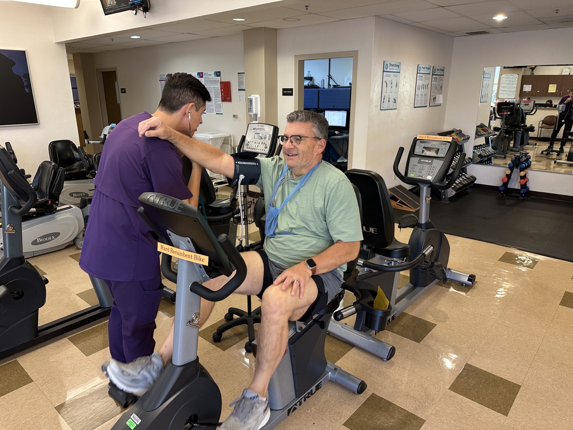 Greg D'Ana on a stationery bike while exercise physiologist checks his stats